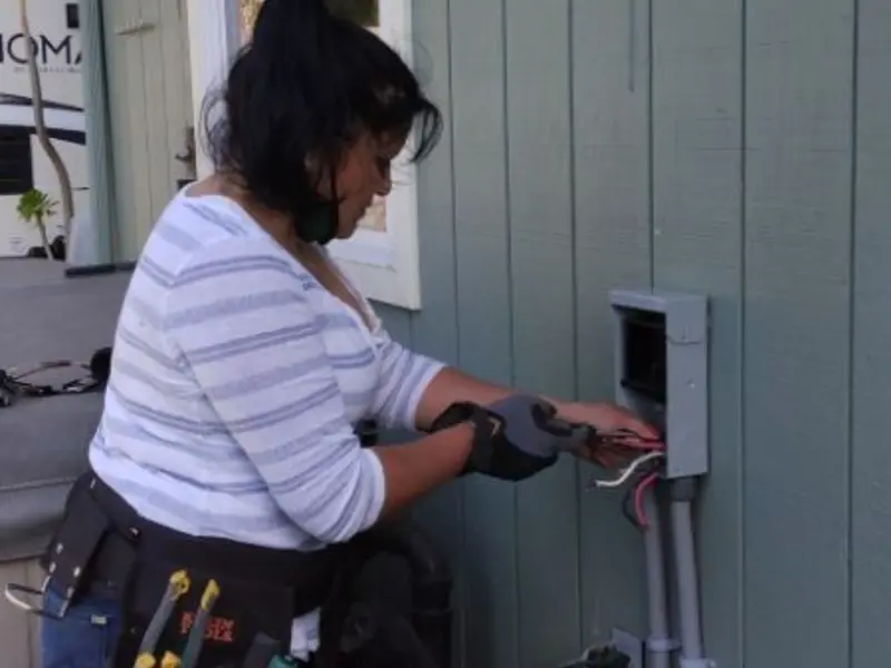 Licensed electrician wiring an exterior subpanel in Kennesaw State University